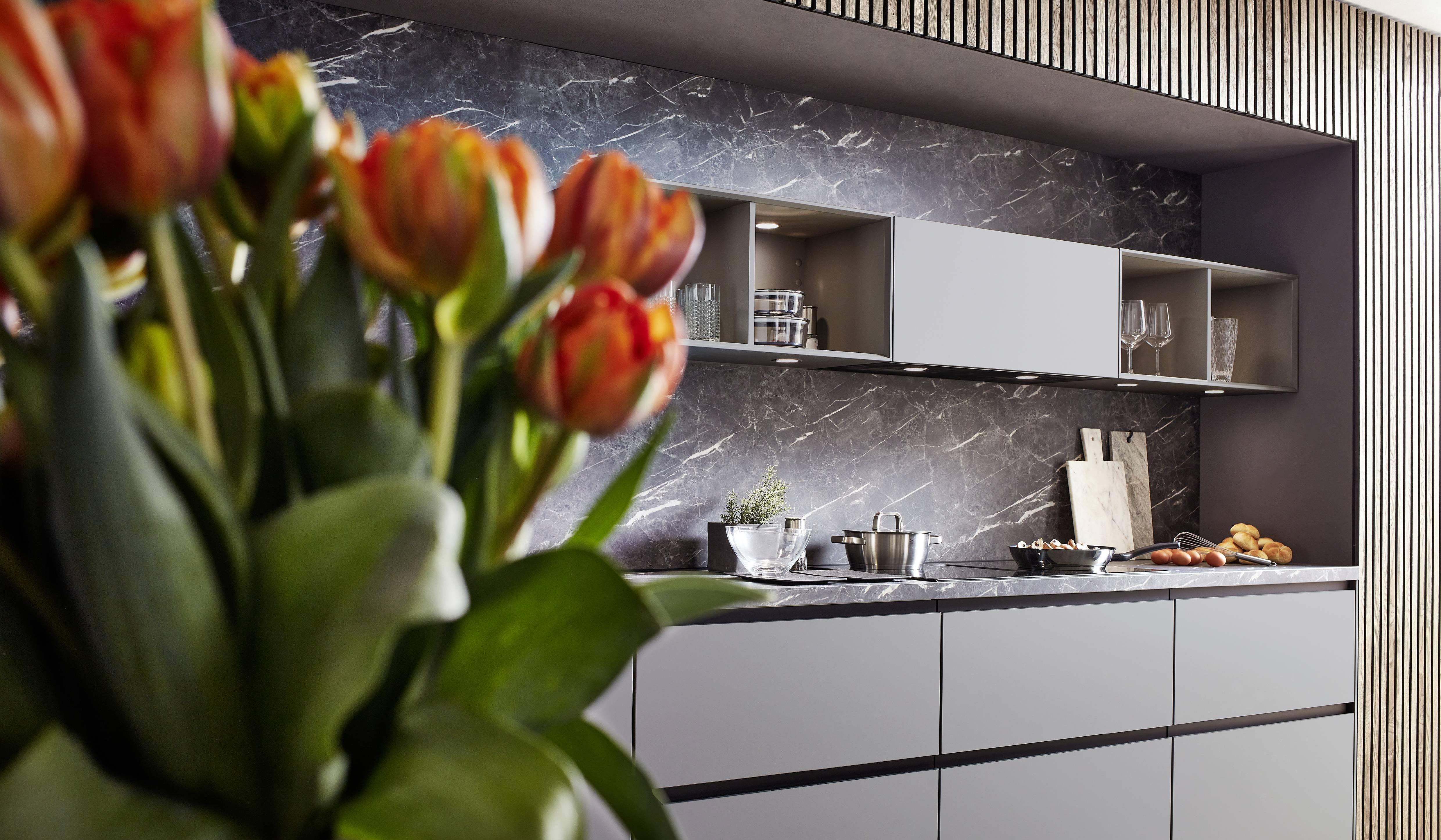 Nobilia Lichtgrau mit Marmordekor und mit roten Tulpen